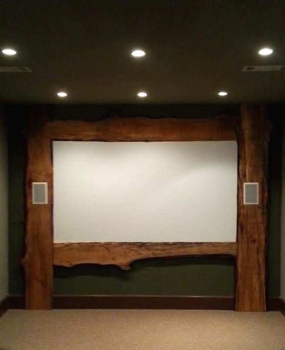 This is an example of a large traditional enclosed home theatre in Birmingham with green walls, carpet, a projector screen and beige floor.