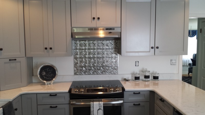 Example of a small minimalist l-shaped kitchen design in Philadelphia with a farmhouse sink, recessed-panel cabinets, white cabinets, stainless steel appliances and a peninsula