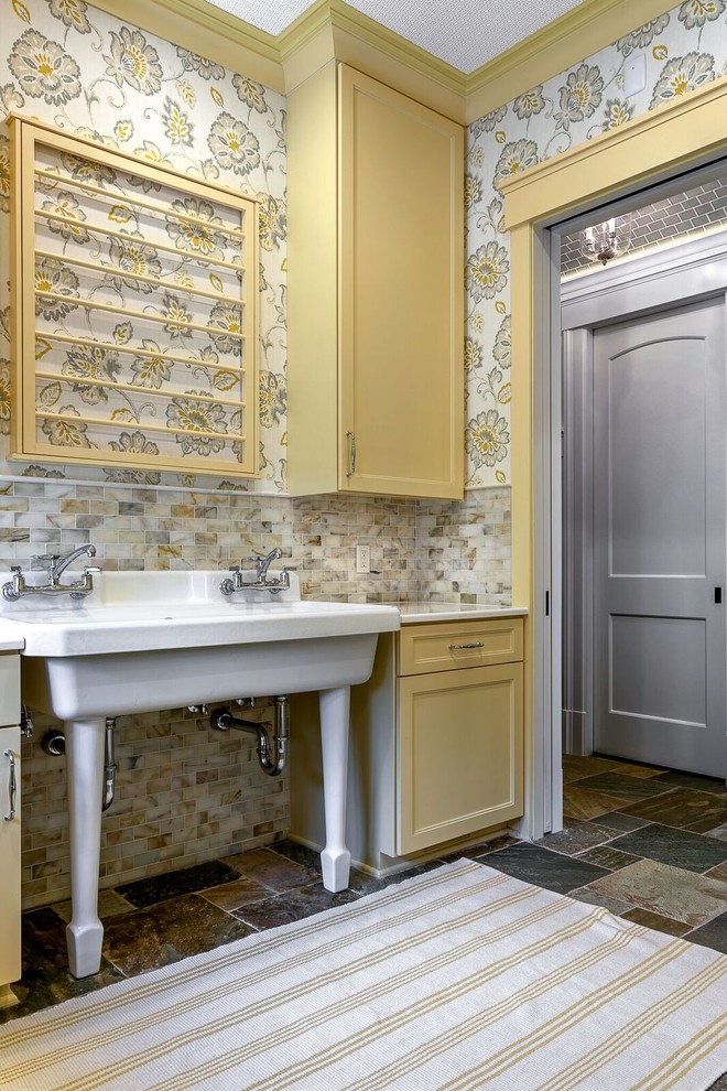 Inspiration for a large country dedicated laundry room in Detroit with recessed-panel cabinets, yellow cabinets, quartzite benchtops, slate floors and grey floor.