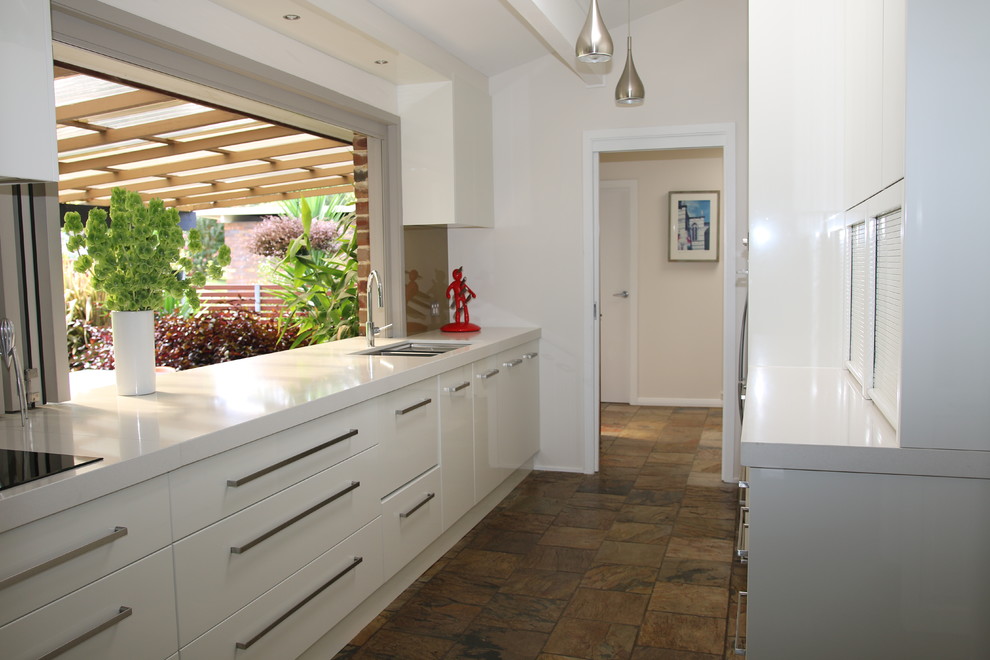 Inspiration for a large modern galley kitchen pantry in Sydney with an undermount sink, flat-panel cabinets, white cabinets, quartz benchtops, brown splashback, glass sheet splashback, stainless steel appliances, slate floors and no island.