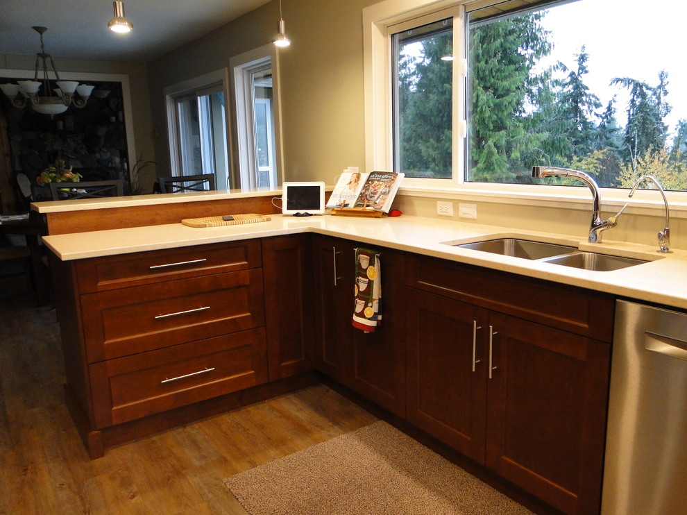 Design ideas for a large transitional u-shaped eat-in kitchen in Vancouver with an undermount sink, recessed-panel cabinets, medium wood cabinets, quartz benchtops, stainless steel appliances, linoleum floors and a peninsula.