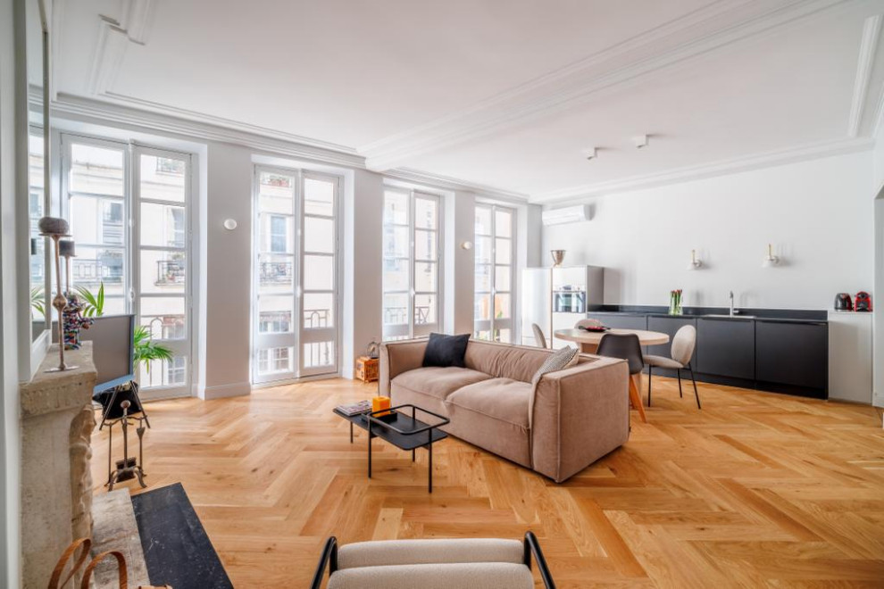 Mittelgroßes, Offenes Modernes Wohnzimmer mit weißer Wandfarbe, hellem Holzboden, Kamin, Kaminumrandung aus Stein, braunem Boden und Holzdecke in Paris