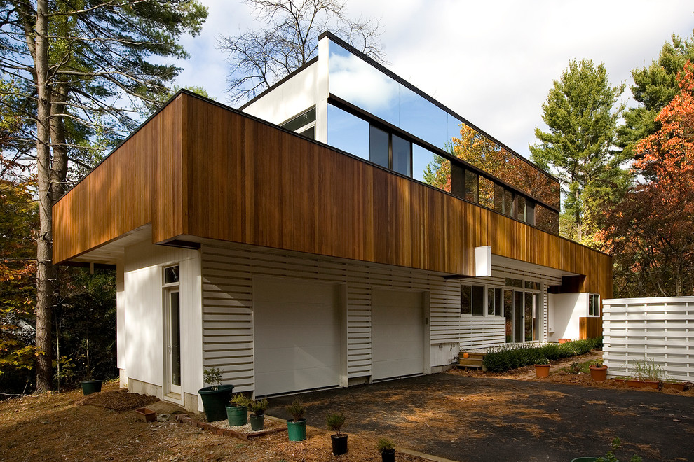 Inspiration for a large midcentury two-storey multi-coloured exterior in Boston with mixed siding and a flat roof.