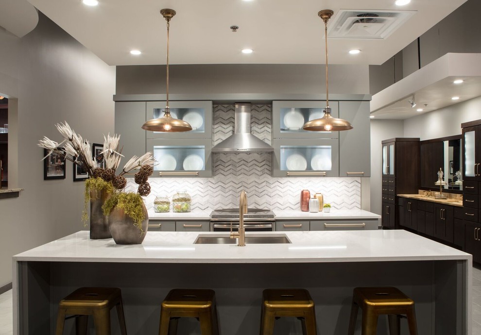 Mid-sized modern single-wall open plan kitchen in Austin with an undermount sink, flat-panel cabinets, grey cabinets, quartzite benchtops, grey splashback, glass tile splashback, stainless steel appliances, with island, marble floors, white floor and white benchtop.
