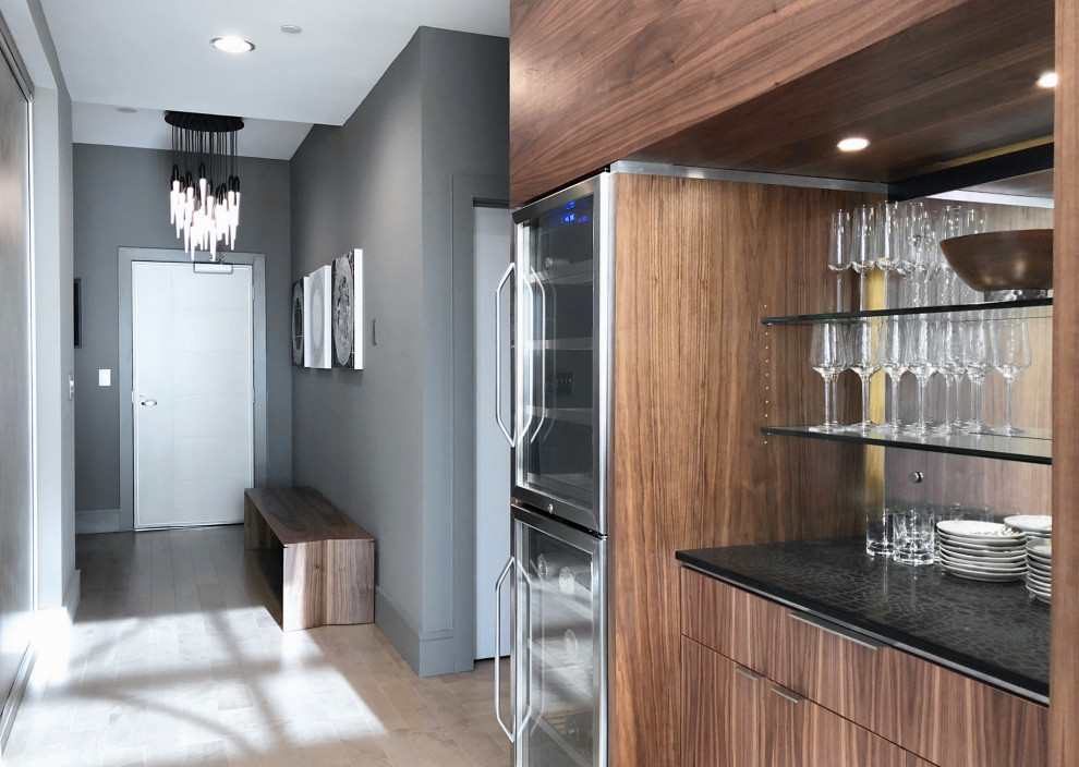 Small modern single-wall seated home bar with no sink, flat-panel cabinets, medium wood cabinets, quartzite benchtops, mirror splashback, light hardwood floors and grey floor.