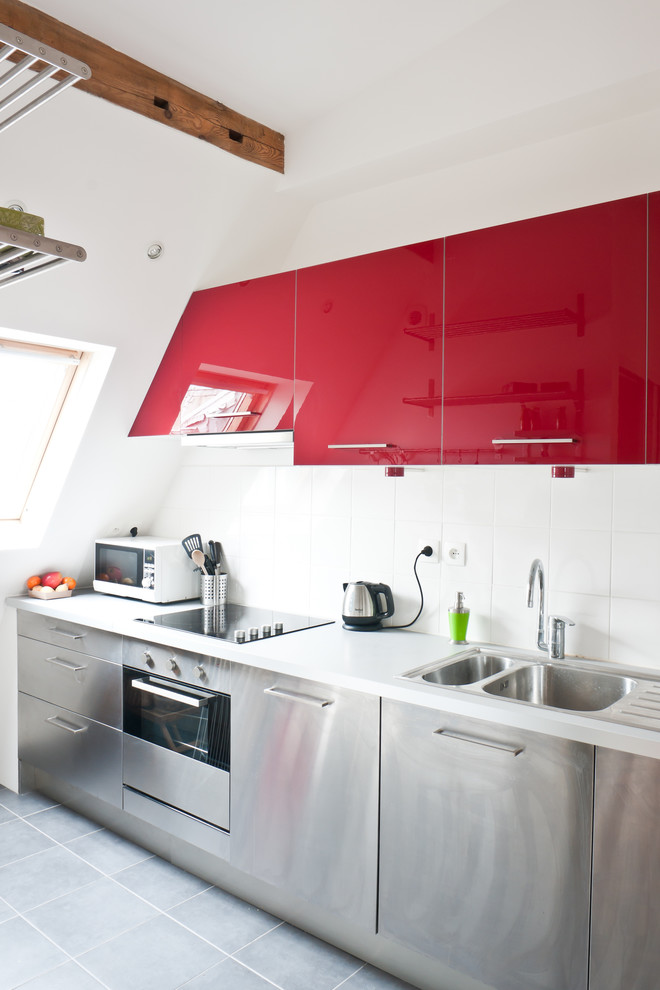 Photo of a mid-sized contemporary single-wall separate kitchen in Paris with a double-bowl sink, flat-panel cabinets, red cabinets, white splashback, stainless steel appliances and no island.