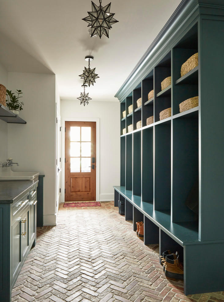 Пример оригинального дизайна: большой тамбур со шкафом для обуви в стиле кантри с белыми стенами, кирпичным полом, одностворчатой входной дверью, входной дверью из дерева среднего тона и красным полом