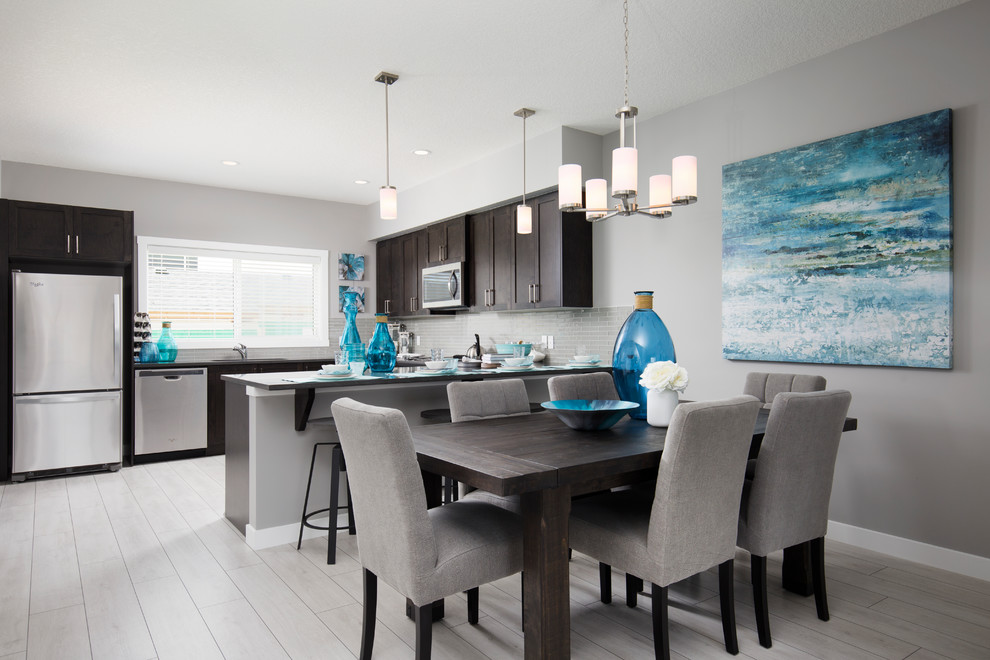 This is an example of a mid-sized contemporary open plan dining in Calgary with grey walls, laminate floors and grey floor.