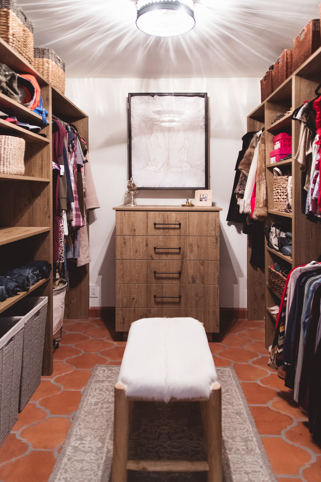 Inspiration for a large gender-neutral walk-in wardrobe in San Diego with flat-panel cabinets, medium wood cabinets, terra-cotta floors and orange floor.