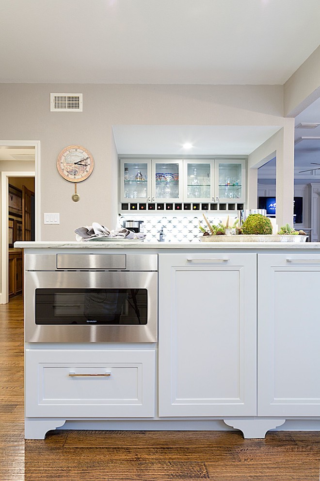 Mid-sized transitional dark wood floor kitchen photo in Dallas with a double-bowl sink, recessed-panel cabinets, white cabinets, quartzite countertops, blue backsplash, glass tile backsplash, stainless steel appliances and an island