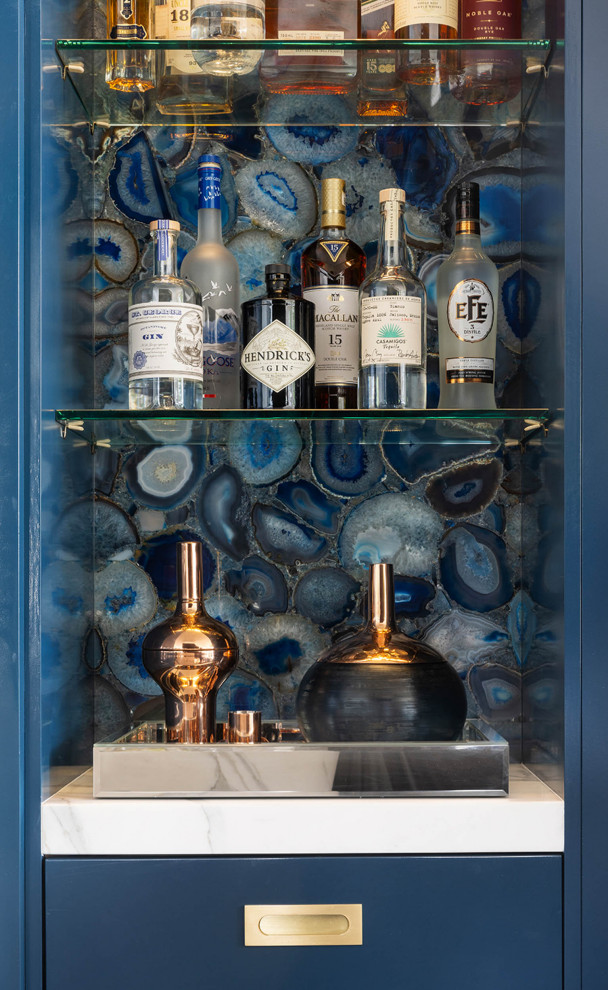 Immagine di un ampio angolo bar classico con ante lisce, ante blu e top bianco