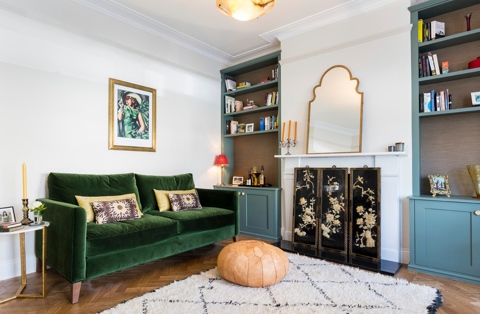 This is an example of a mid-sized asian enclosed living room in London with a library, white walls, medium hardwood floors, a standard fireplace and a stone fireplace surround.