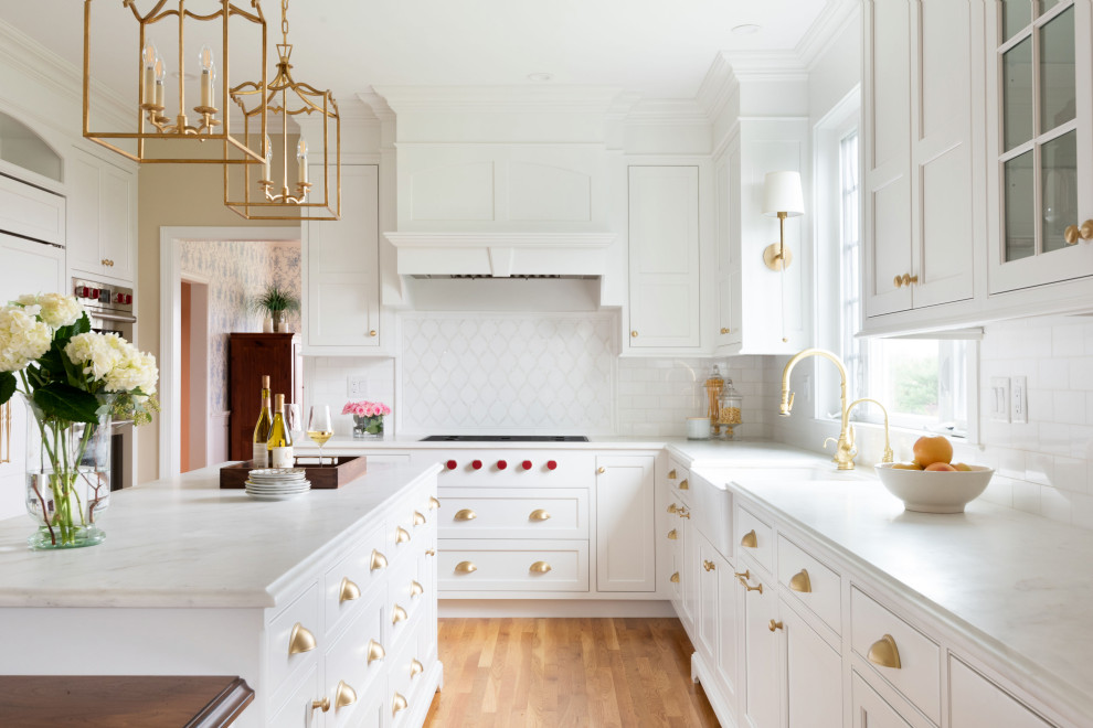 Exempel på ett stort klassiskt vit vitt u-kök, med vita skåp, marmorbänkskiva och en köksö
