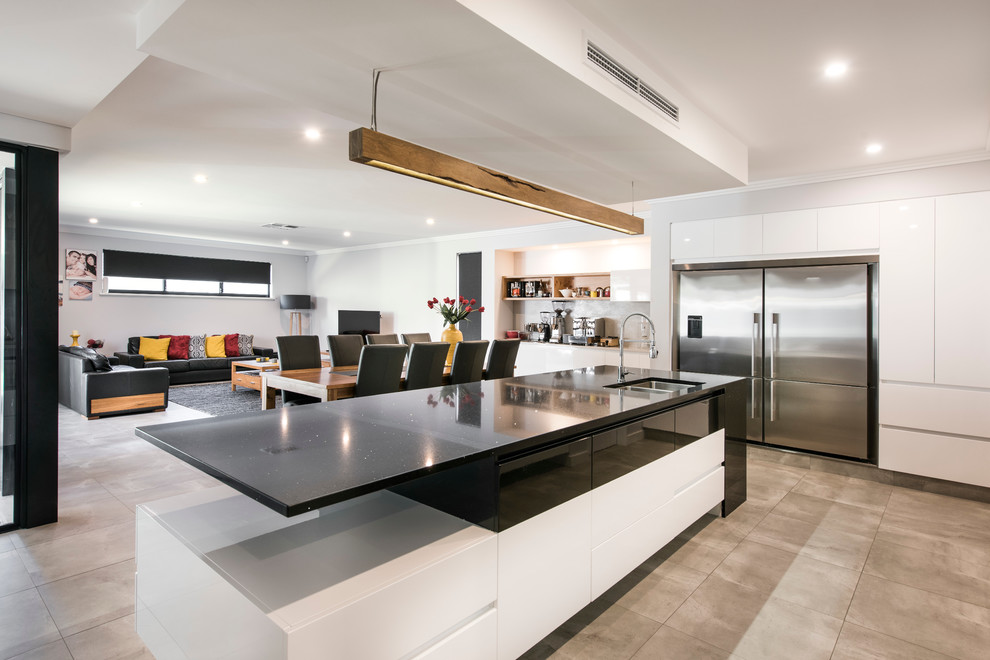 This is an example of a mid-sized contemporary single-wall open plan kitchen in Perth with an undermount sink, flat-panel cabinets, white cabinets, quartz benchtops, grey splashback, porcelain splashback, stainless steel appliances and with island.