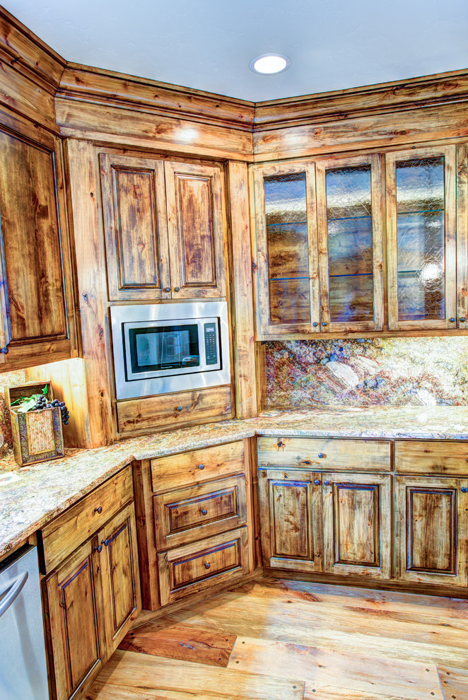Large mountain style u-shaped medium tone wood floor kitchen pantry photo with a drop-in sink, glass-front cabinets, medium tone wood cabinets, beige backsplash, stainless steel appliances and an island