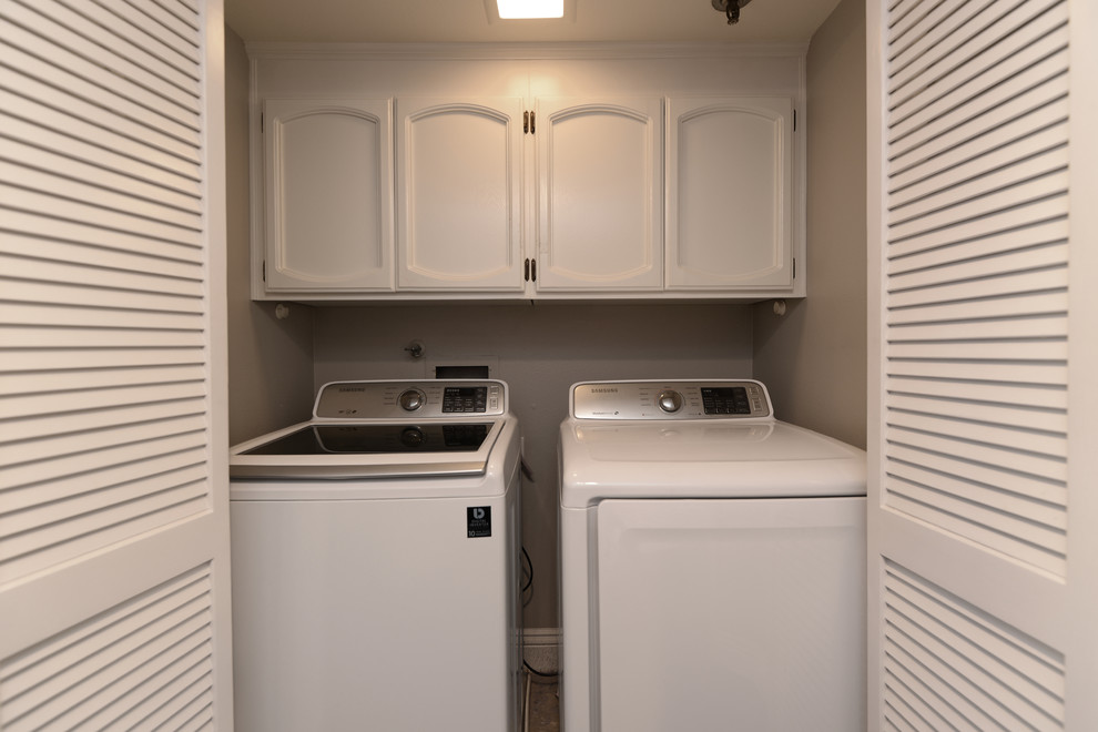 Inspiration for a small beach style single-wall laundry cupboard in San Diego with beaded inset cabinets, white cabinets, grey walls, dark hardwood floors and a side-by-side washer and dryer.