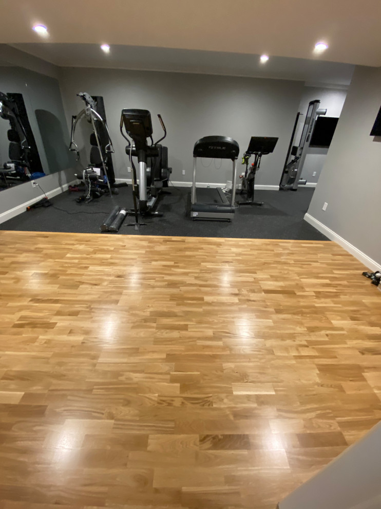 Mid-sized transitional home weight room in New York with grey walls and medium hardwood floors.