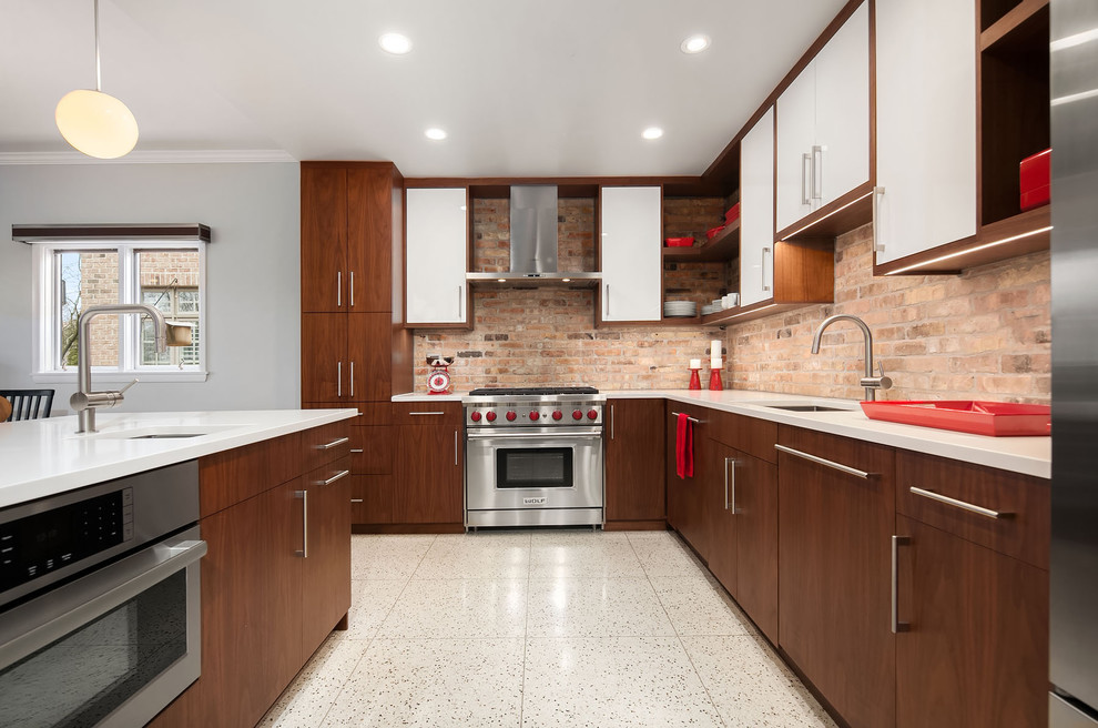 Photo of a mid-sized midcentury l-shaped eat-in kitchen in Chicago with an undermount sink, flat-panel cabinets, white cabinets, brick splashback, stainless steel appliances, terrazzo floors, with island, brown splashback, beige floor and quartz benchtops.