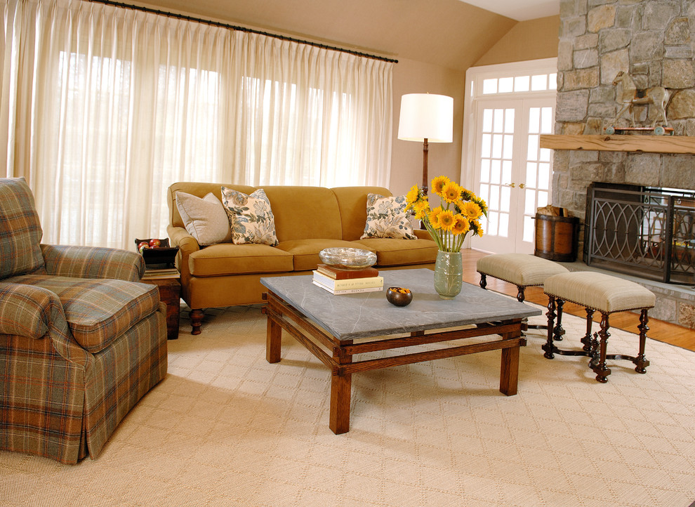 Large traditional living room in New York with medium hardwood floors, a standard fireplace, a stone fireplace surround and beige walls.