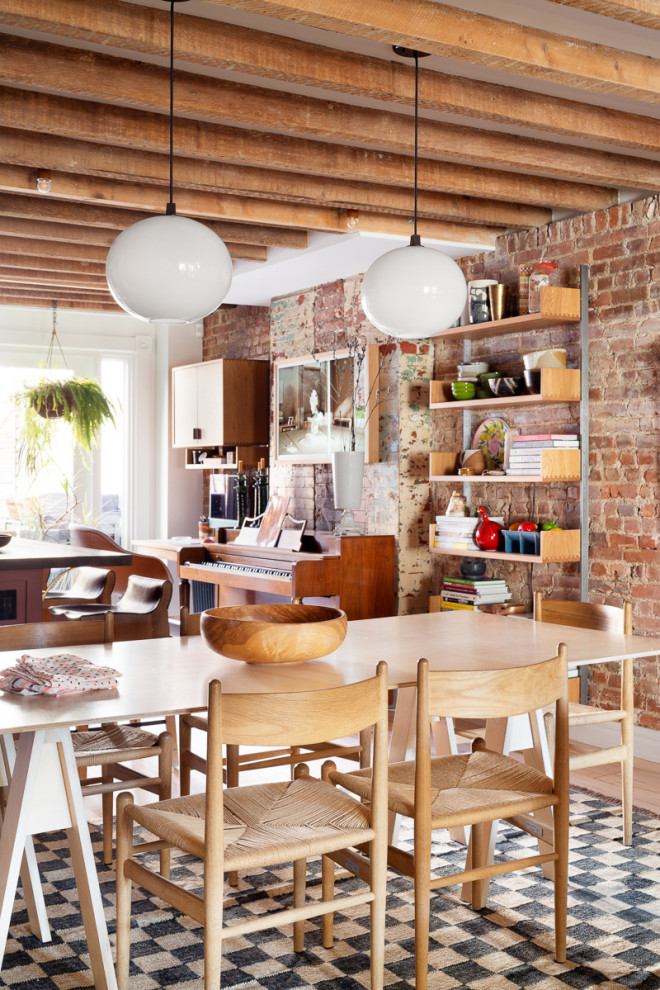 Inspiration for a bohemian open plan dining room in New York with red walls, light hardwood flooring, beige floors, exposed beams and brick walls.