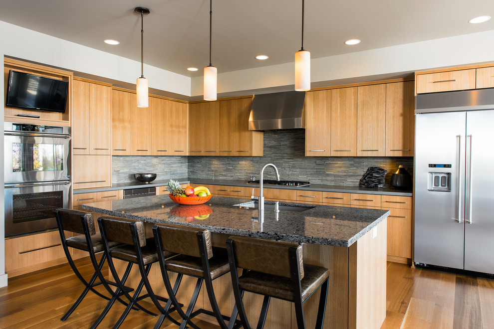 This is an example of a mid-sized contemporary l-shaped separate kitchen in Other with an undermount sink, flat-panel cabinets, light wood cabinets, concrete benchtops, grey splashback, matchstick tile splashback, stainless steel appliances, light hardwood floors, with island and brown floor.