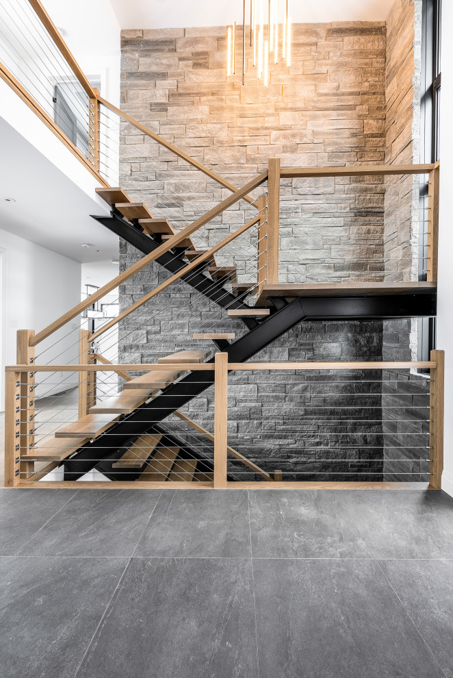 Imagen de escalera contemporánea sin contrahuella con escalones de madera y barandilla de cable