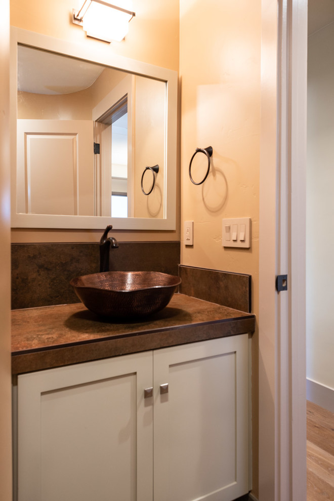 Inspiration for a mid-sized arts and crafts master bathroom in San Luis Obispo with shaker cabinets, a drop-in sink, blue cabinets, yellow walls and brown benchtops.