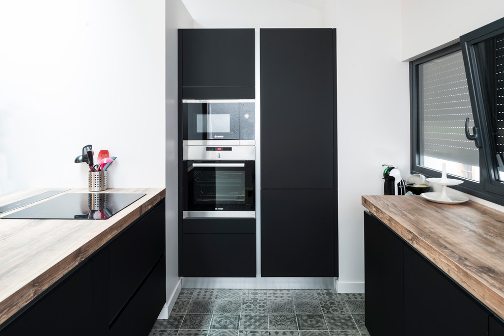 Large contemporary u-shaped open plan kitchen in Grenoble with a double-bowl sink, recessed-panel cabinets, black cabinets, wood benchtops, panelled appliances, ceramic floors and with island.