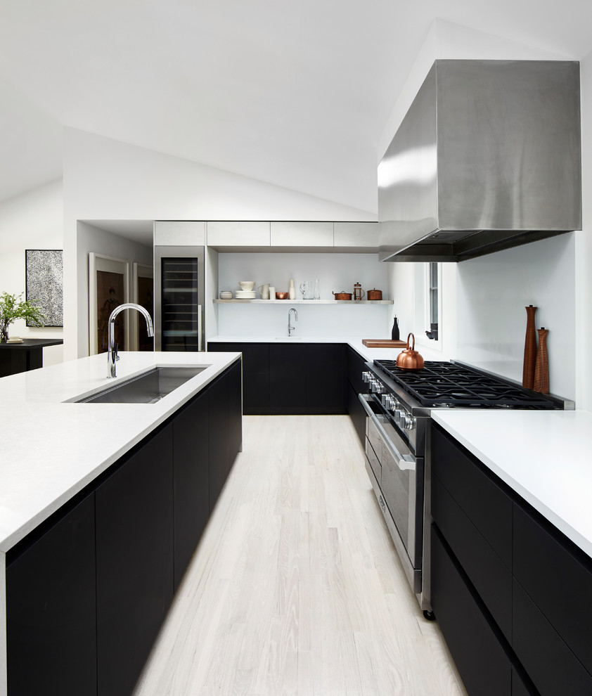 Design ideas for a mid-sized modern u-shaped open plan kitchen in New York with an undermount sink, flat-panel cabinets, white splashback, stainless steel appliances, light hardwood floors, with island, beige floor and quartz benchtops.