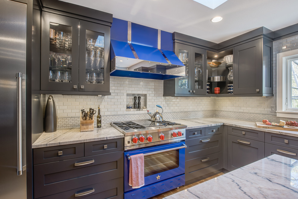 Inspiration for a large transitional u-shaped light wood floor eat-in kitchen remodel in Denver with a farmhouse sink, recessed-panel cabinets, gray cabinets, quartzite countertops, blue backsplash, ceramic backsplash, stainless steel appliances and an island