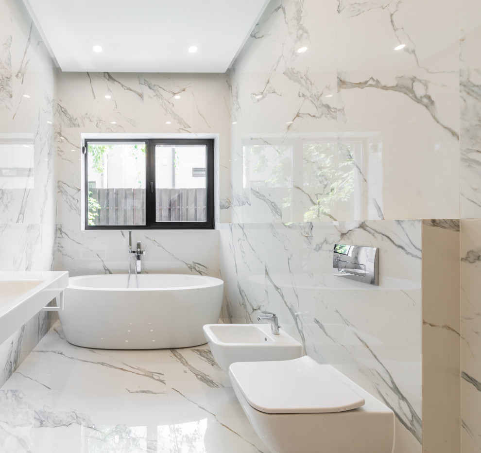 Ispirazione per una stanza da bagno minimal con vasca idromassaggio, piastrelle in gres porcellanato e pavimento bianco