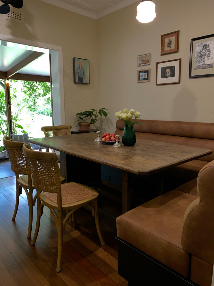 This is an example of a small transitional dining room in Brisbane with beige walls, dark hardwood floors and brown floor.