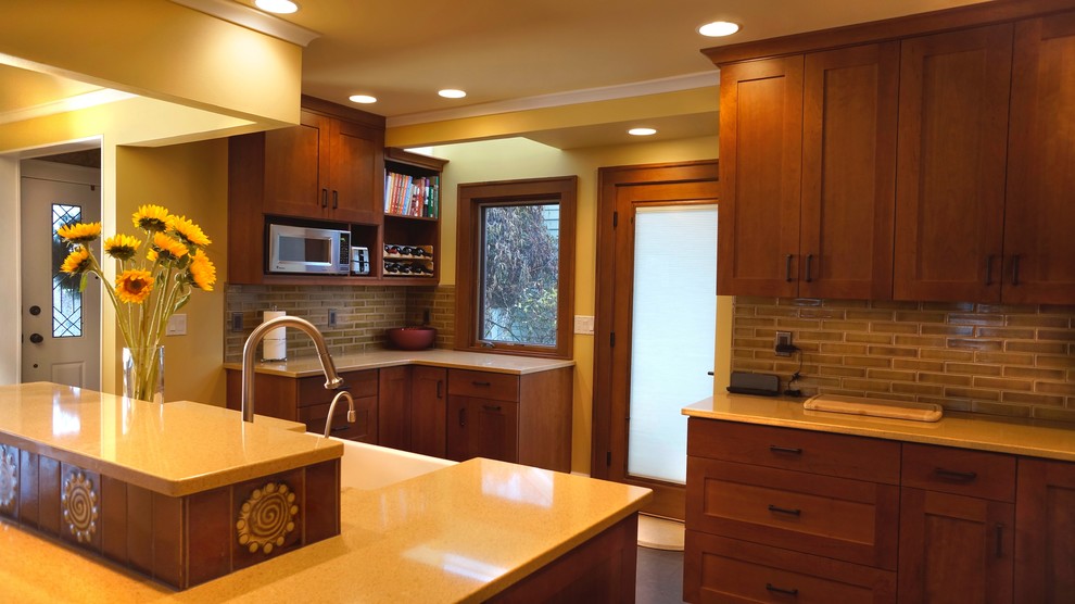 Arts and crafts eat-in kitchen in Seattle with a farmhouse sink, shaker cabinets, medium wood cabinets, quartz benchtops, green splashback, porcelain splashback and stainless steel appliances.