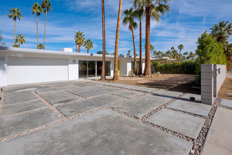 Photo of a large midcentury front yard full sun driveway for winter in Other with a fire feature and decking.