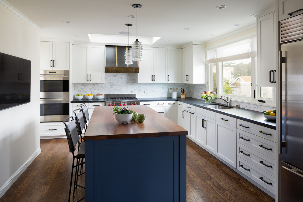 Kitchen - mid-sized transitional l-shaped dark wood floor and brown floor kitchen idea in San Francisco with shaker cabinets, white cabinets, an island, white backsplash, stainless steel appliances, an undermount sink, marble backsplash and black countertops