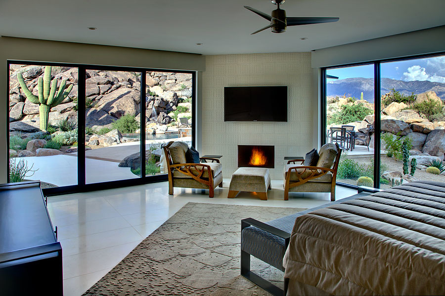 This is an example of a large contemporary master bedroom in Phoenix with grey walls, porcelain floors, a ribbon fireplace, a tile fireplace surround and beige floor.