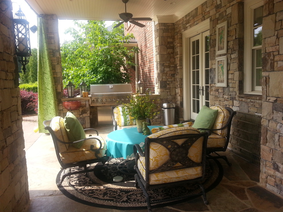 Photo of a large traditional backyard patio in Atlanta with natural stone pavers, a roof extension and a fire feature.