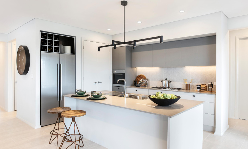 Inspiration for a large contemporary open plan kitchen in Wollongong with a double-bowl sink, shaker cabinets, grey cabinets, quartz benchtops, grey splashback, ceramic splashback, stainless steel appliances, cement tiles, with island, grey floor and grey benchtop.
