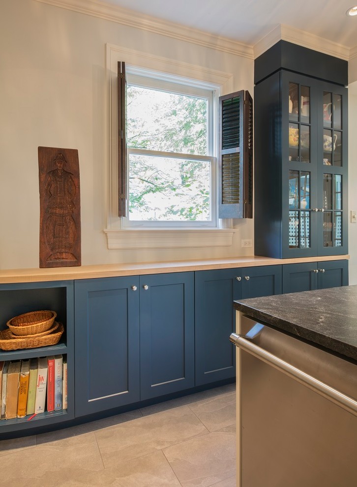 Inspiration for a mid-sized transitional u-shaped separate kitchen in DC Metro with an undermount sink, shaker cabinets, blue cabinets, wood benchtops, white splashback, ceramic splashback, stainless steel appliances, ceramic floors, a peninsula, grey floor and yellow benchtop.