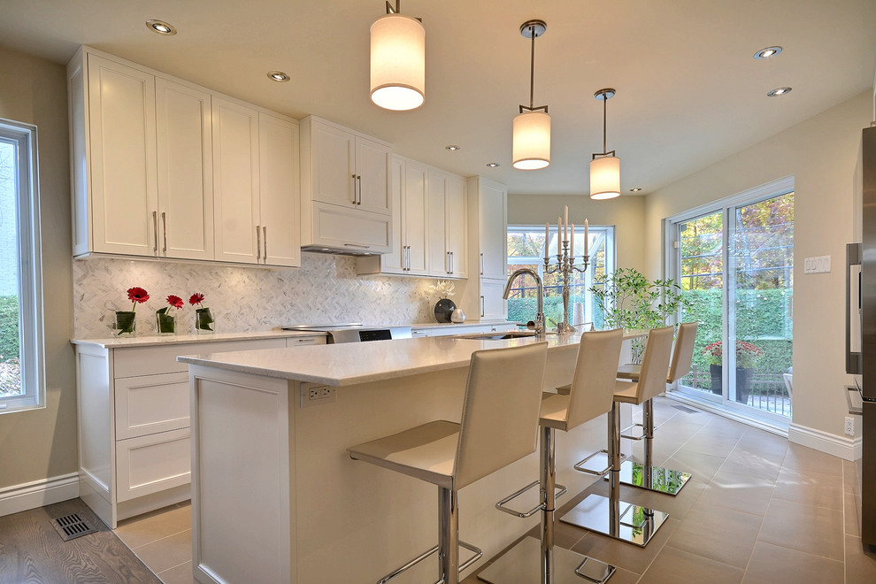 Inspiration for a contemporary kitchen in Montreal with white cabinets, quartz benchtops, grey splashback, mosaic tile splashback, stainless steel appliances, porcelain floors and with island.