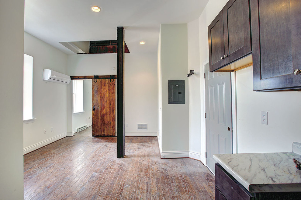 Inspiration for a small transitional single-wall medium tone wood floor and brown floor kitchen remodel with recessed-panel cabinets, dark wood cabinets, white backsplash, no island, white countertops and laminate countertops