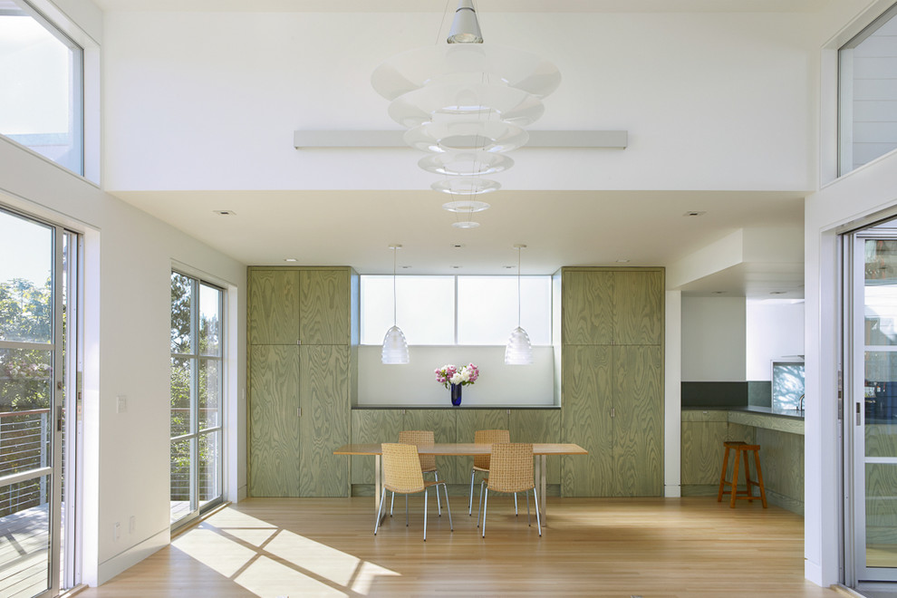 This is an example of a contemporary dining room in San Francisco with white walls and light hardwood floors.