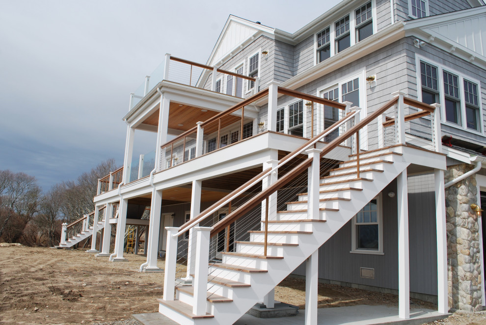 Photo of a large beach style two-storey grey house exterior in Providence with wood siding, a gable roof, a grey roof and shingle siding.