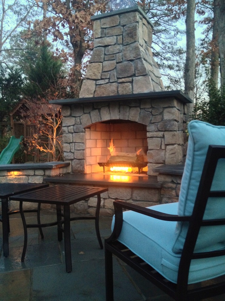 This is an example of a mid-sized traditional backyard patio in Richmond with a fire feature, natural stone pavers and no cover.