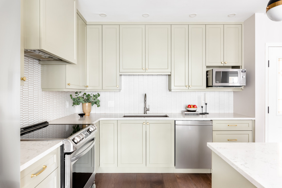 Kitchen - small transitional brown floor kitchen idea with shaker cabinets, green cabinets, white backsplash, stainless steel appliances, an island and white countertops
