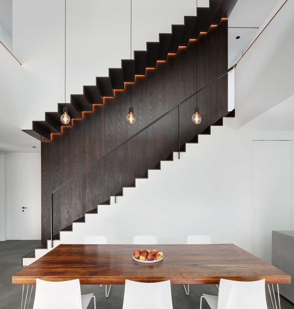 This is an example of a mid-sized contemporary wood straight staircase in Munich with wood risers and metal railing.