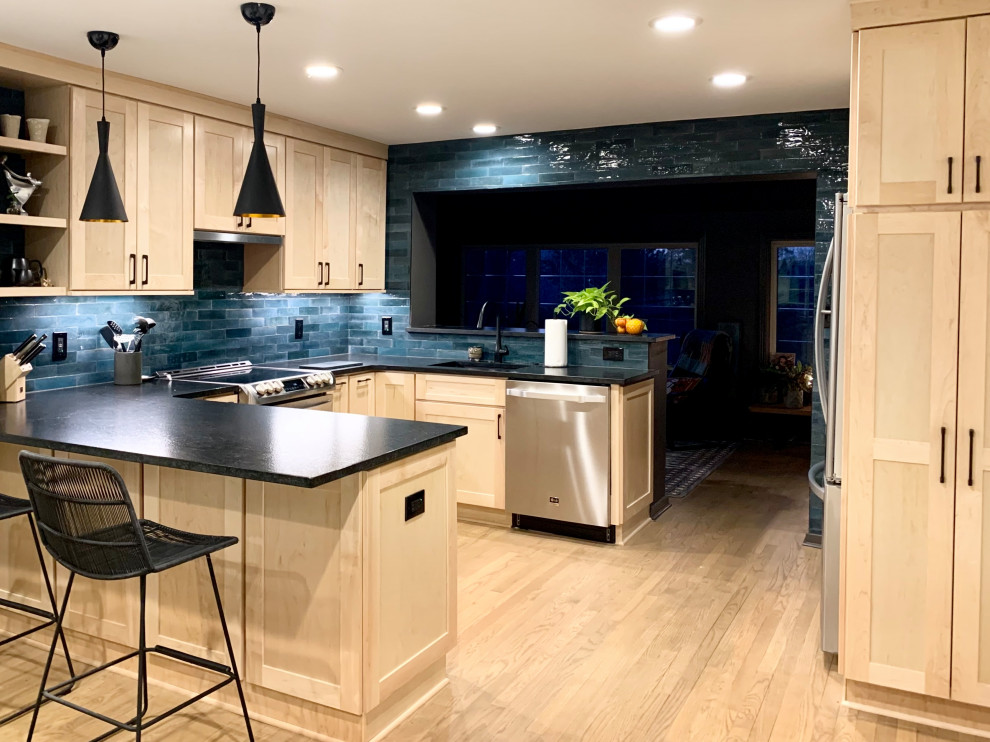 Eat-in kitchen - mid-sized transitional u-shaped light wood floor and brown floor eat-in kitchen idea with an undermount sink, shaker cabinets, light wood cabinets, granite countertops, blue backsplash, ceramic backsplash, stainless steel appliances, a peninsula and black countertops