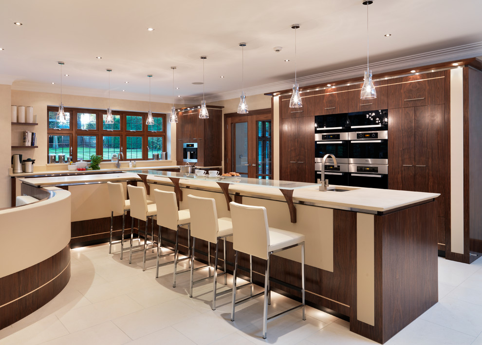 This is an example of a large contemporary l-shaped eat-in kitchen in Kent with an undermount sink, flat-panel cabinets, dark wood cabinets, quartzite benchtops, stainless steel appliances, limestone floors and with island.