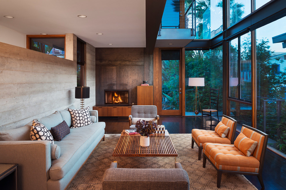 Large trendy formal and open concept dark wood floor and brown floor living room photo in Los Angeles with gray walls, a standard fireplace, a plaster fireplace and no tv