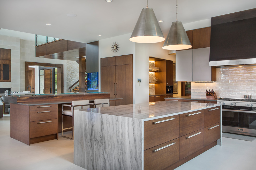 Contemporary l-shaped open plan kitchen in Dallas with flat-panel cabinets, medium wood cabinets, stainless steel appliances, multiple islands and beige floor.